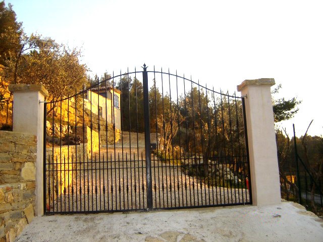 Fabrication et pose d'un portail barreaudé en fer forgé, sur mesure à la Cadière d'Azur. Choix de différents ornements possible.