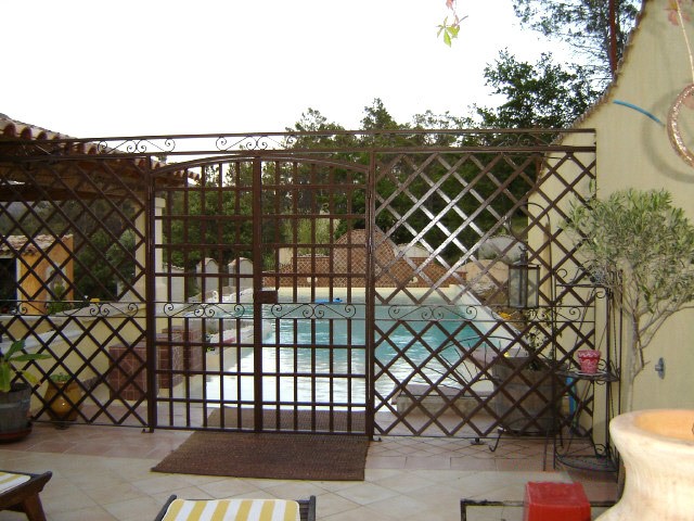 Fabrication et pose d'une clôture et porte en fer forgée fermant l'accès à la piscine, à Meoune.